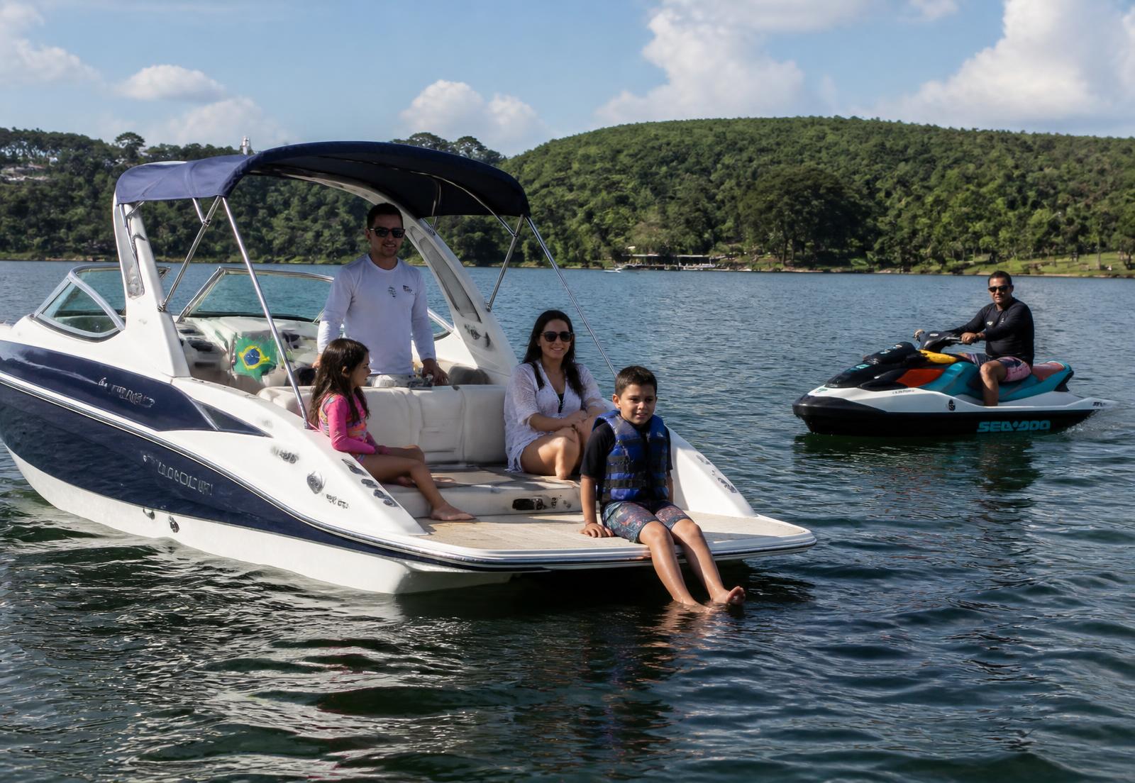 Família aproveitando um barco com uma moto náutica ao lado