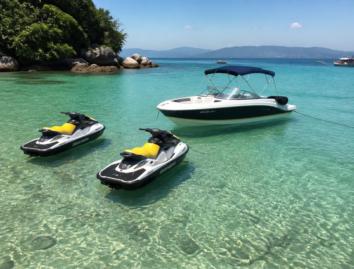 Motos náuticas e barco ancorados em uma baía